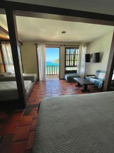 1 dormitorio con cama y vistas al océano en Orlanova Hotel, en Arraial do Cabo