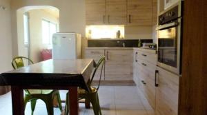 a kitchen with a table and a white refrigerator at La Bergerie in Condamine-Châtelard