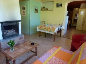 a living room with a table and a fireplace at La Bergerie in Condamine-Châtelard