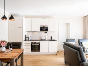 eine Küche mit weißen Schränken und einem Holztisch in der Unterkunft Quartier Frohsinn, App. 08 in Ahlbeck