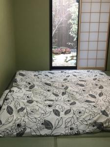 1 cama con edredón blanco y negro y ventana en 翠云間 庭院式京町屋 京都四条西院 en Kyoto