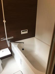 翠云間 庭院式京町屋 京都四条西院 في كيوتو: حوض استحمام أبيض في حمام مع حوض