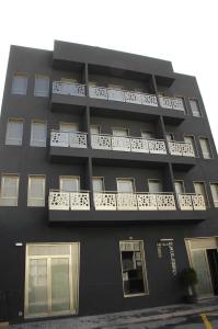 un edificio negro con balcones blancos. en Hotel La Colombina en San Sebastián de la Gomera