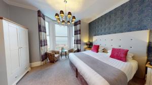 a bedroom with a large bed and a large window at Tynedale Hotel in Llandudno
