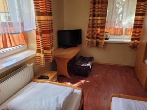 Kleines Zimmer mit einem Bett und einem TV in der Unterkunft ZAJAZD KANSAS in Konstantynów Łódzki