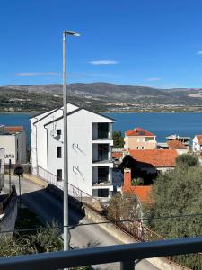 a white building with a view of a body of water at Apartments Holiday Gavric in Trogir