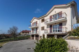 SermérieuT3 Les Tilleuls Sermerieu的一栋带阳台和停车场的白色建筑 更多22张照片