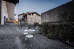 duas cadeiras e uma mesa em frente a uma parede em Monolocali di Cà Selvetta Holiday Houses em Morbegno