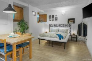 um quarto com uma cama, uma mesa e uma sala de jantar em Monolocali di Cà Selvetta Holiday Houses em Morbegno