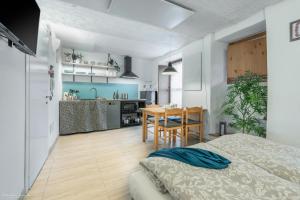 Habitación con cama y cocina con mesa en Monolocali di Cà Selvetta Holiday Houses, en Morbegno