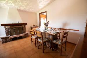 een eetkamer met een tafel en stoelen en een open haard bij B&B Casa Gioconda in Monte Vidon Combatte