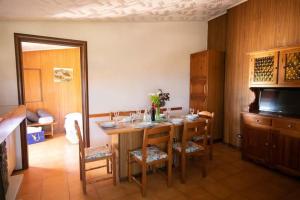 een eetkamer met een tafel met stoelen en een televisie bij B&B Casa Gioconda in Monte Vidon Combatte