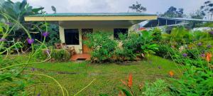 a small house with a garden in front of it at Granja Agua Azul, Wi-FI,AC-WC,Parking,la Fortuna in Fortuna
