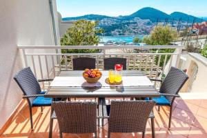 a table with a bowl of fruit on a balcony at Apartment Piano in Dubrovnik