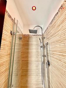 a shower stall in a bathroom with wooden walls at B&B Romeo in Bari