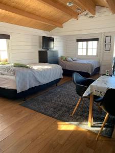 1 dormitorio con 2 camas, mesa y TV en Steinnýjarstaðir en Skagaströnd