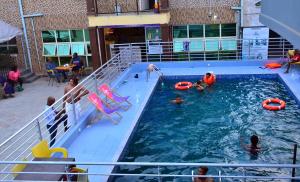 un gruppo di persone in una piscina su una nave da crociera di 24-7 Electricity Agore Hotels and Suites Ltd a Awoyaya
