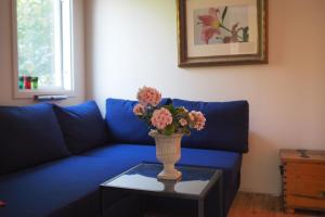 een blauwe bank met een vaas met bloemen op een tafel bij Brukshotellet Öland - kursgård och vandrarhem in Degerhamn