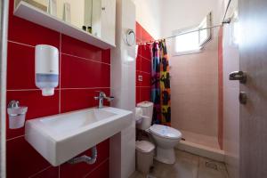 a red bathroom with a sink and a toilet at Giasemi Room No 4 Anafi in Livadi Astypalaias