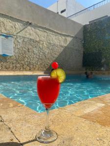 卡塔赫納的住宿－Hotel Toledo FL，在游泳池旁的玻璃杯中喝一杯