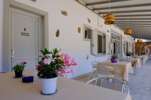 a row of tables and chairs with flowers on them at Giasemi Room No 4 Anafi in Livadi Astypalaias