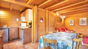 a dining room with a table and a kitchen at Bois de Champelle - 14 - Chalet cosy - 6 pers in Morillon