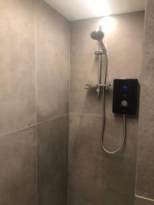 a bathroom with a shower with a light on the wall at Brand new studio outhouse Putney SW15 in London