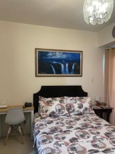 um quarto com uma cama, uma secretária e um quadro em INSPIRIA 1803 Studio Unit with Balcony beside Abreeza Mall Davao em Davao