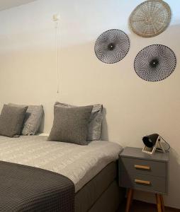 een slaapkamer met een bed met een nachtkastje en 2 ventilatoren aan de muur bij Strandslag Juliana 201 in Julianadorp