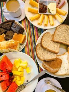 una mesa con platos de comida y una taza de café en BC Paradise Hostel & Suítes, en Balneário Camboriú