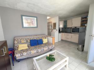 salon z kanapą i stołem w obiekcie AQUAPLAGE Joli appartement RDC piscine 1 ère ligne mer Richelieu Cap d'Agde w Cap d'Agde