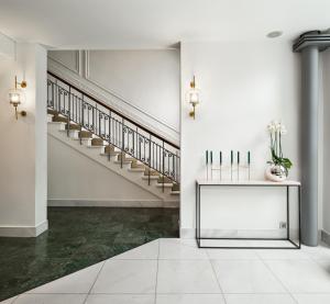 a hallway with stairs and a table with flowers at The Excelsior - Small Luxury Hotels of the World in Thessaloniki
