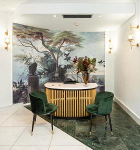 a room with two chairs and a table with a painting at The Excelsior - Small Luxury Hotels of the World in Thessaloniki