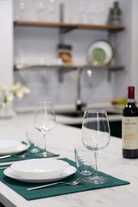 - une table avec deux verres, une assiette et une bouteille de vin dans l'établissement CA' LUCIA - Affitti Brevi Italia, à Milan
