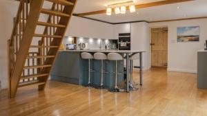 a kitchen with a counter and a bar with stools at West Farm Cottage in Godmanchester