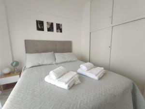 Un dormitorio con una cama blanca con toallas. en Beautiful apartment in Palermo en Buenos Aires