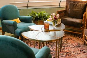 a living room with two chairs and a table with flowers on it at The Excelsior - Small Luxury Hotels of the World in Thessaloniki