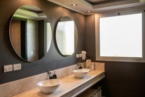 2 lavabos en un baño con 2 espejos en Villas Del Malbec Lodges en Agrelo