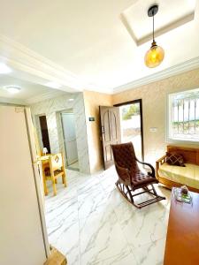 - un salon avec une chaise et un lit dans l'établissement Seaside Guest House, à Ghār al Milḩ