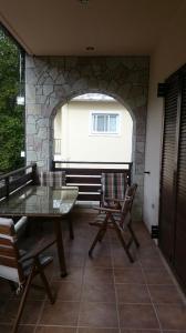 un patio con mesa, sillas y pared de piedra. en VILLA RIA en Kalavryta