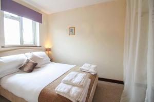 a bedroom with a bed with towels on it at Sunny Corner Cottage in Hayle