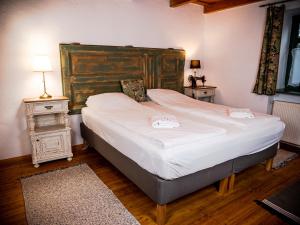 1 dormitorio con 1 cama grande y cabecero de madera en Fekete Gólya XL, en Tiszafüred