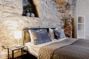- une chambre avec un lit et un mur en pierre dans l'établissement Dream Stay - Old Town City Wall Studio Apartment, à Tallinn
