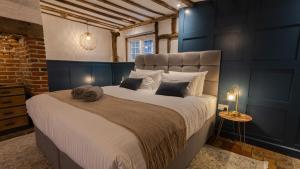 a bedroom with a large bed with blue walls at West Farm Cottage in Godmanchester