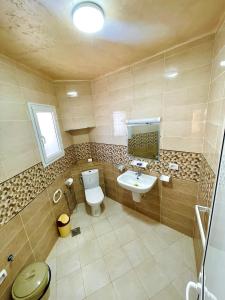 a bathroom with a toilet and a sink at Seaside Guest House in Ghār al Milḩ