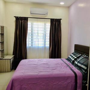 a bedroom with a purple bed and a window at 88 Cozy House in Kuala Selangor