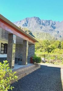 a house with a mountain in the background at Charmante maison au cœur des 3 montagnes in Salazie