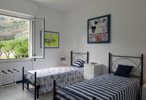 a bedroom with two beds and a window at La Brezza Marina in Fezzano