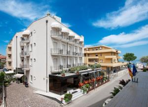 ein weißes Gebäude mit Balkon auf einer Straße in der Unterkunft Hotel Gabriella in Rimini
