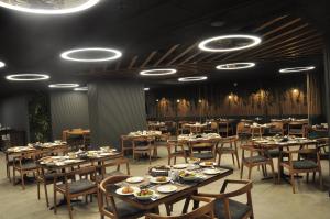 a dining room with tables and chairs and lights at Happy Inn Gebze Hotel in Kocaeli